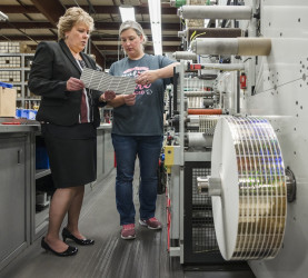 From left, Lori Campbell and Press Operator Jen Salazar discuss the customer expectations of a job being run at The Label Printers.
