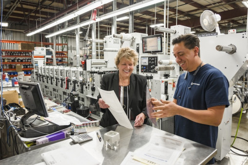 From left, Lori Campbell, president of The Label Printers, reviews a job with Press Operator Dan Brain.